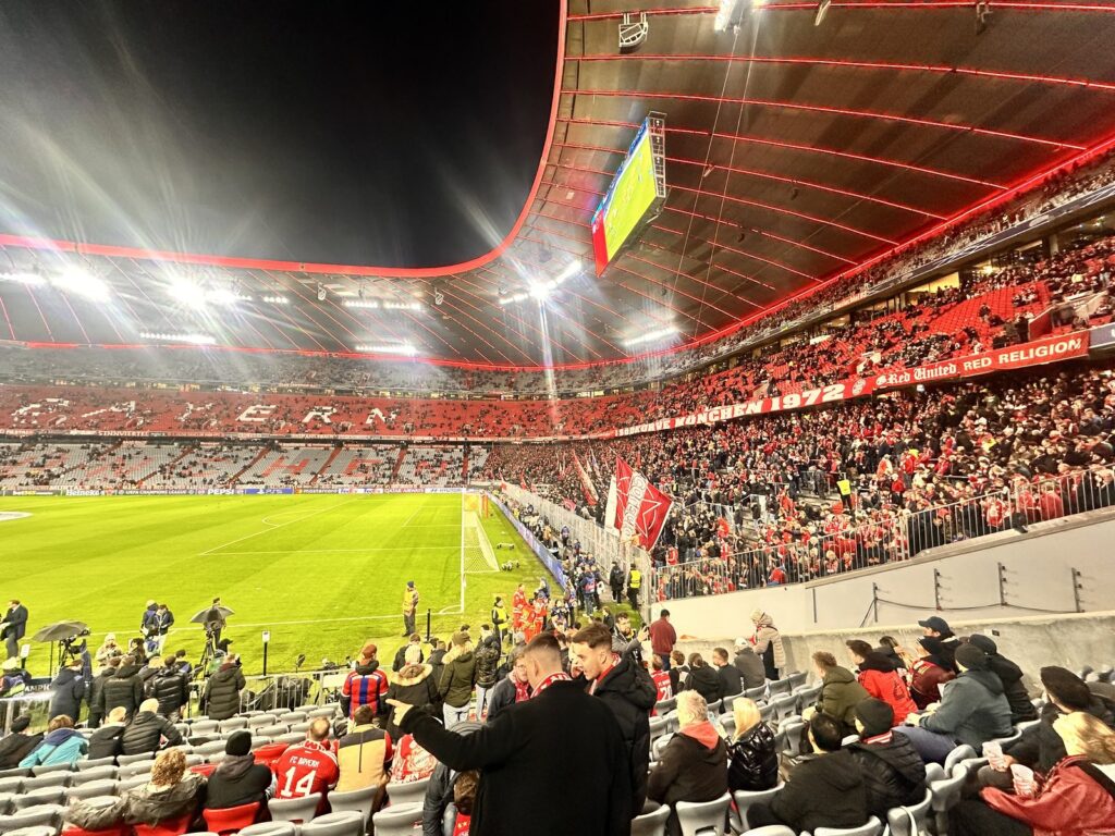 Blick aus dem Unterrang der Allianz Arena auf Fans und Spielfeld vor dem Anpfiff