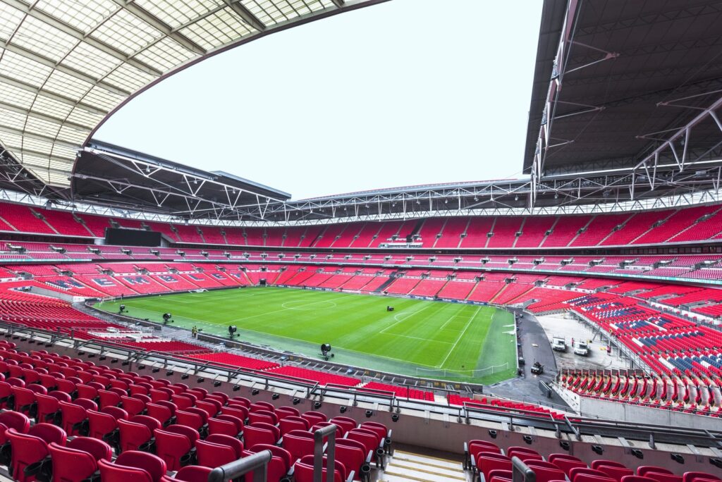 Innenraum des Wembley-Stadions mit roten Sitzen und Dach
